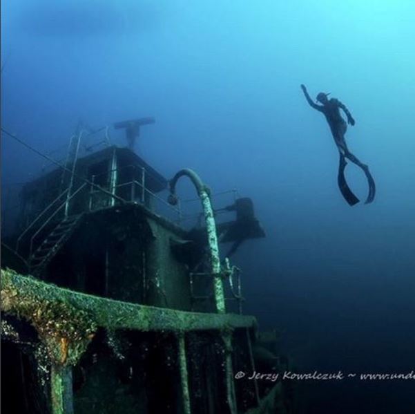 Freedive instructor emerging from a wreck
